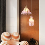 Load image into Gallery viewer, Pair of Butterfly pendant lamps with pink stained glass shades and gold accents, including a scalloped and geometric design, hanging in a modern living room with a leather accent wall, striped armchair, and decorative dried foliage.
