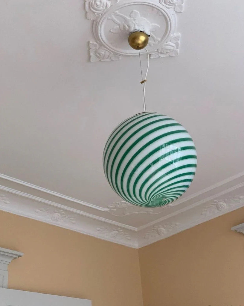 This green and white striped Candy pendant lamp hanging from the ceiling, set against a neutral-colored room background, adds a whimsical, contemporary touch to the space.