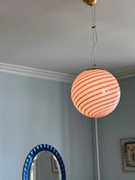 Load image into Gallery viewer, Candy pendant lamp with a soft pink and white striped globe-shaped shade, suspended from the ceiling, complemented by a blue circular mirror and light pastel walls, adding a whimsical touch to the room.
