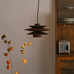 Load image into Gallery viewer, Cylindrical Pendant Light with a tiered metal design in a deep brown finish, suspended in a minimalist kitchen setting with wooden cabinetry and dried botanical decor, creating a warm and inviting ambiance.
