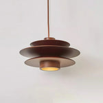 Load image into Gallery viewer, Cylindrical Pendant Light with a sleek layered metal design in a warm brown finish, suspended from a single cord, showcasing a contemporary style and soft downlight glow against a neutral background.
