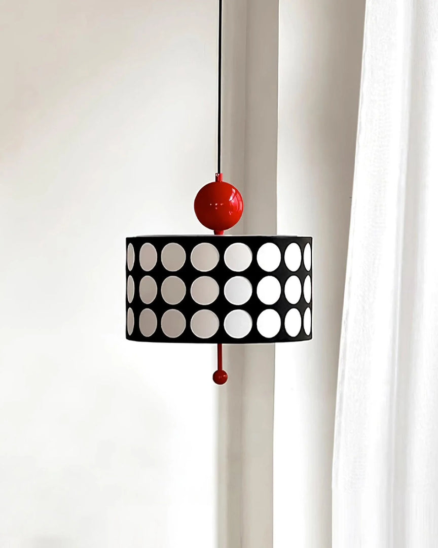 Gracefully designed Metal Lattice Pendant Lamp with a black and white circular motif and vivid red accents, hung near a window draped with a white curtain, enhancing the soft, natural light in a serene setting.