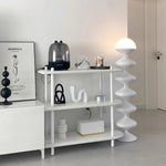 Load image into Gallery viewer, Modern minimalist decor featuring a Spiral Lamp in white with a flowing, sculptural design next to a white shelf unit displaying stylish home accessories. The clean lines of the lamp complement the chic, organized space, which includes a coffee maker, decorative objects, and an art print, creating a refined aesthetic.
