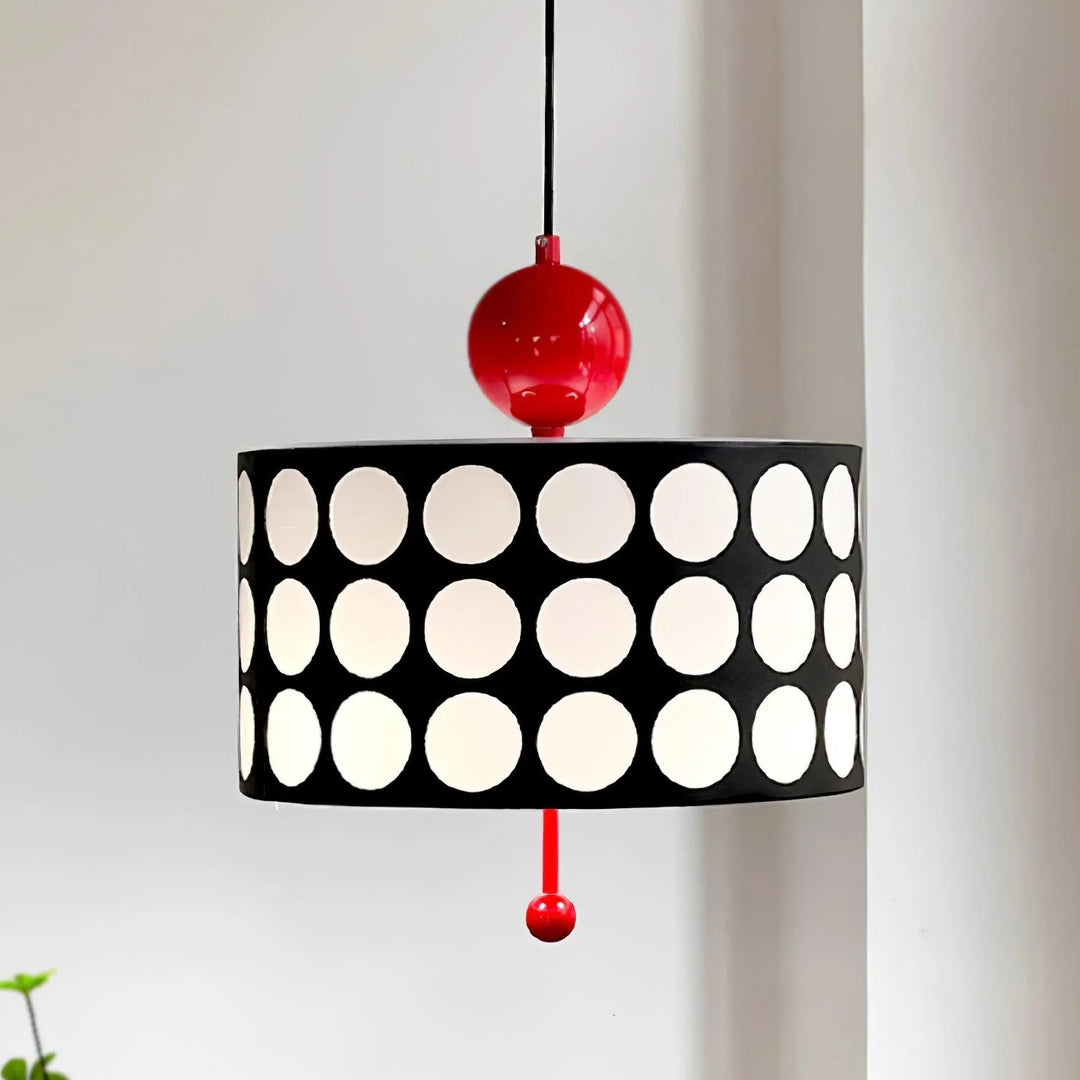 Contemporary metal lattice pendant lamp with a black shade featuring large white circles and a vibrant red top and bottom accent, elegantly displayed against a soft background.