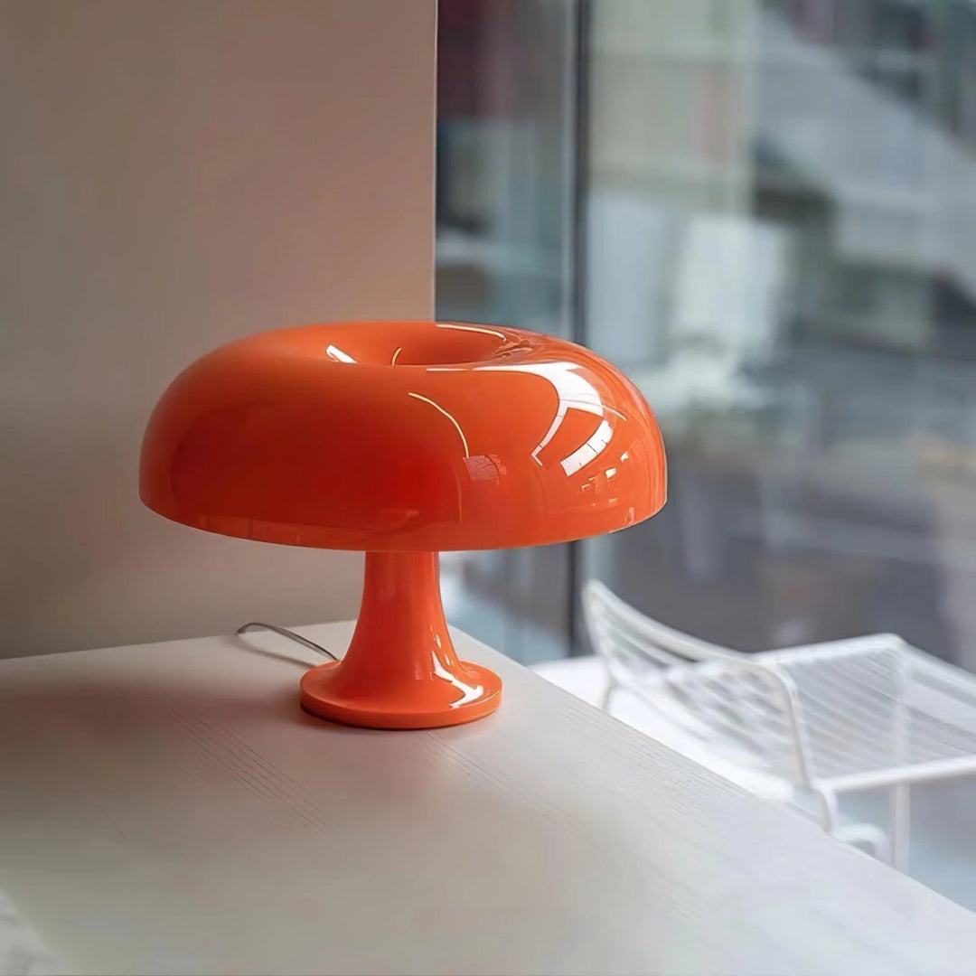 Vibrant orange Mushroom Playful Table Lamp with a sleek, glossy finish, perfectly positioned on a modern table near a window, adding a pop of color and a playful touch to the contemporary interior design.