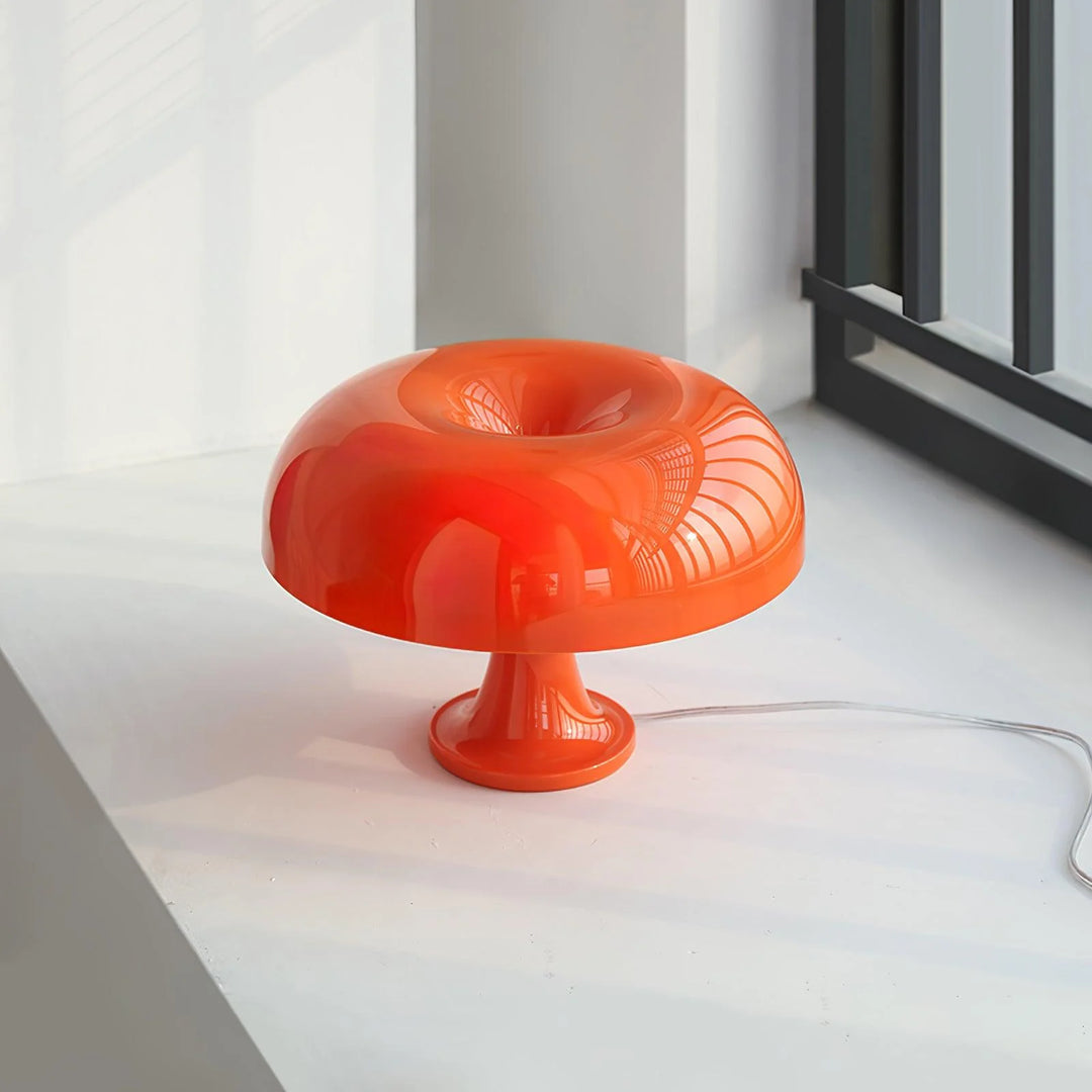 A vibrant orange Mushroom Playful Table Lamp elegantly captures morning light beside a window, its glossy finish and curvaceous design reflecting the serene surroundings in a modern and stylish interior.