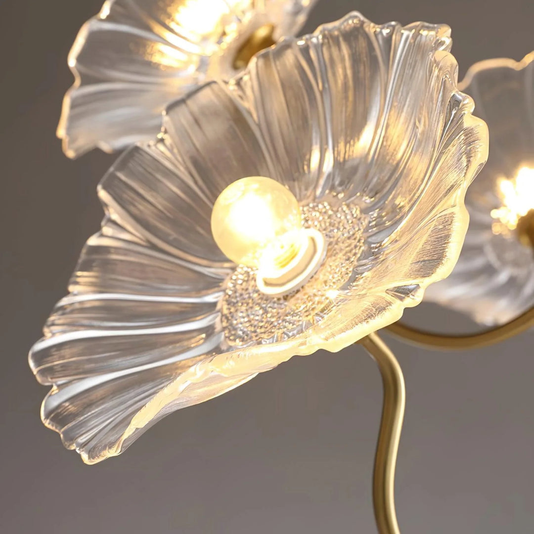 A close-up view of the pendant lamp’s crystal-clear floral shade, showcasing intricate petal-like detailing that diffuses the light from the central bulb beautifully. The golden accents and shimmering textures add a refined elegance, making it a standout feature in any interior decor.