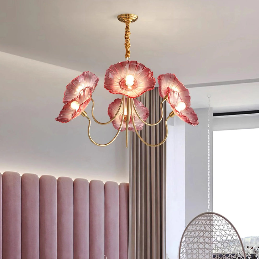 The Oleander Pendant Lamp exquisitely complements a modern, luxurious setting with its shimmering golden frame and vibrant pink shades that resemble oleander blossoms, positioned gracefully above a chic interior, blending elegance with contemporary design.