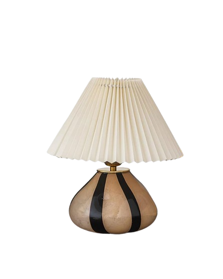 Pleated Cavolo table lamp with a striped ceramic base and cream pleated shade, isolated on a transparent background to highlight its elegant design.