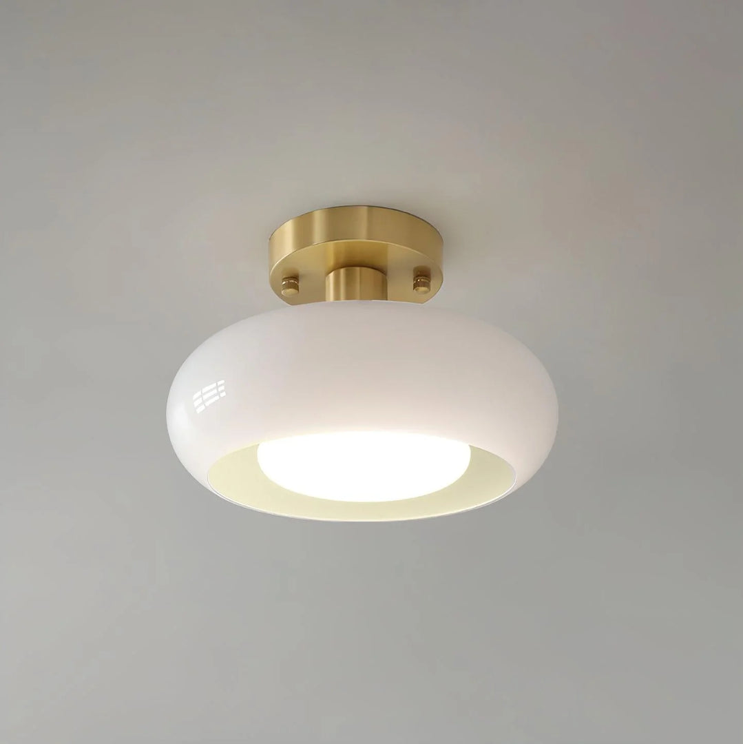 A sleek Sanna cylinder ceiling light with a white glass shade and a brushed brass mount, offering soft and elegant illumination suitable for modern interiors.