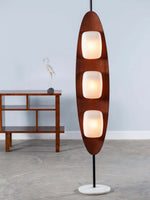 Load image into Gallery viewer, Elegant mid-century modern surfboard-shaped floor lamp in walnut wood featuring three illuminated white glass panels, mounted on a minimalist black metal stem with white marble base, perfect for retro interior lighting design and Danish modern decor
