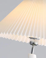 Load image into Gallery viewer, A close-up view of the pleated lampshade of the wavy floor lamp, showcasing its intricate design and metallic fixtures.
