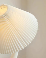 Load image into Gallery viewer, A detailed close-up of the pleated shade of a wavy floor lamp, showcasing its crisp folds and soft white tone against a neutral background.
